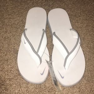 White and grey Nike flip flops